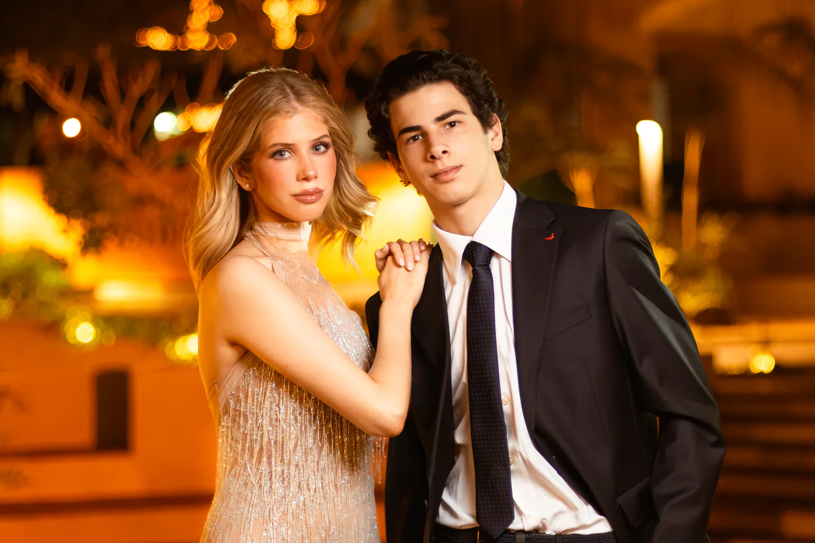 Pareja de modelos con estilismo formal en un entorno nocturno